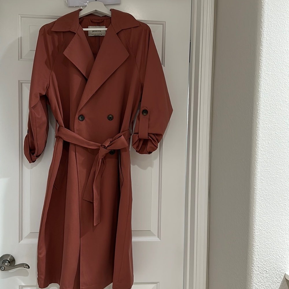Preowned trench coat size medium light salmon color with two pockets in …
